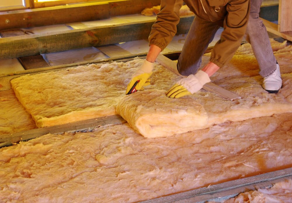 Blanket insulation being installed in a roof