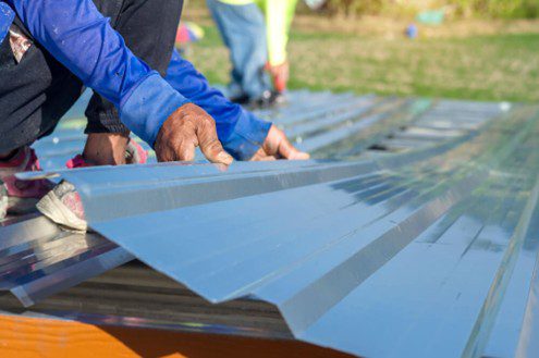 Person Handling Roofing Sheets For Small Projects In Queensland.